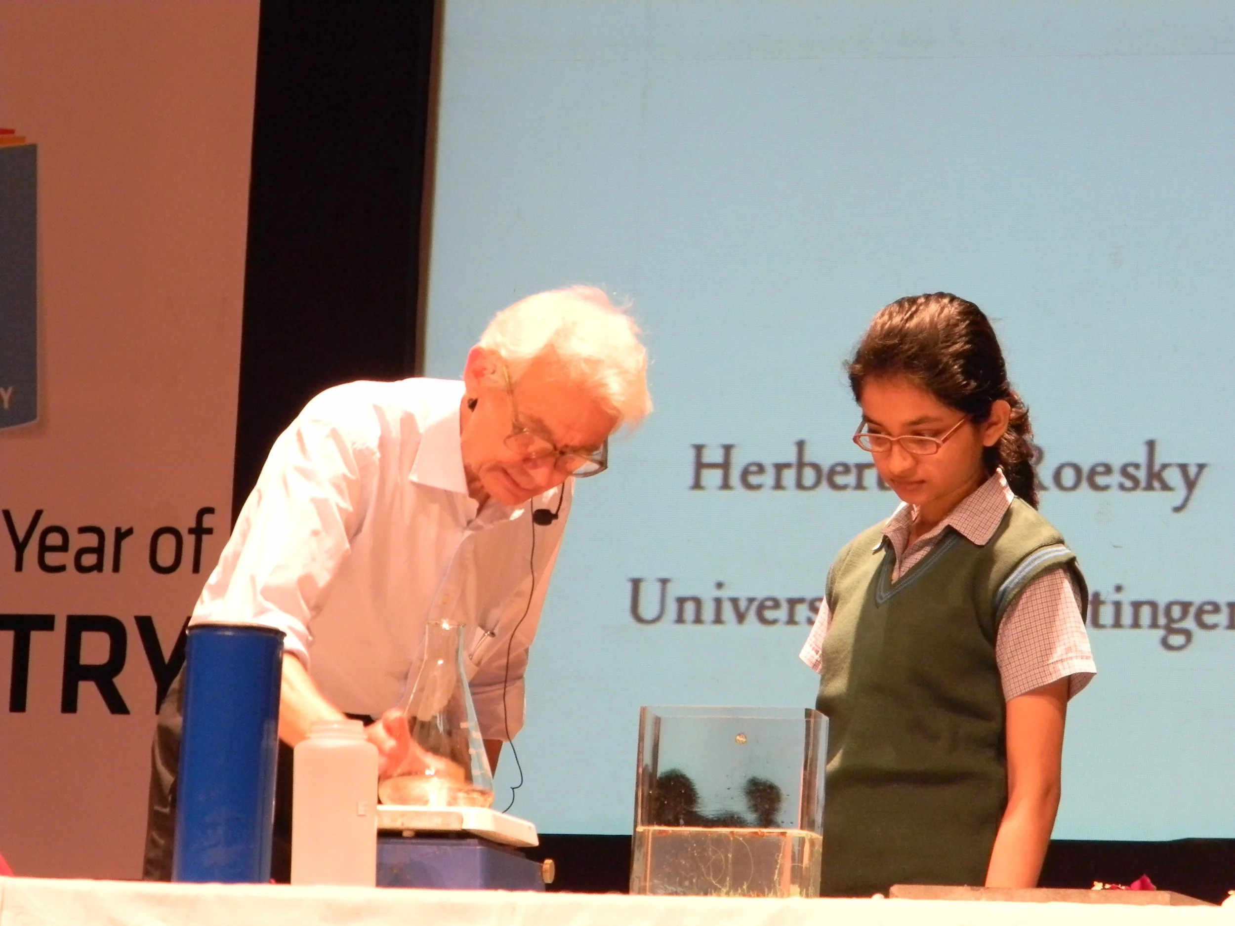 Students are observing the experiment closely and attentively.