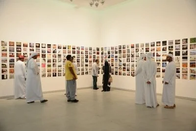 People viewing photographs displayed on gallery walls in an art exhibition