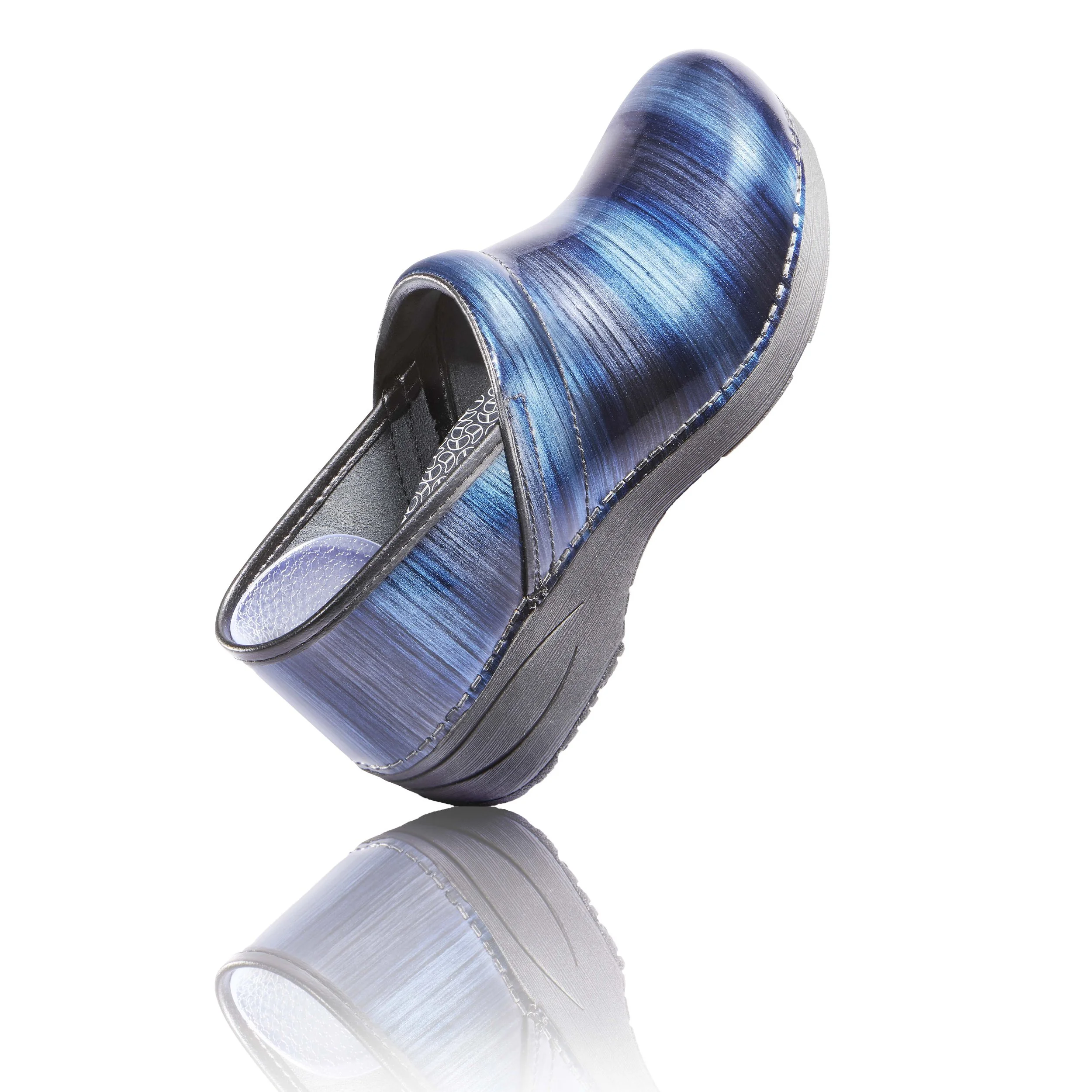 A men's slip-on shoe with a blue and black gradient design and a textured sole, reflected on a shiny surface.