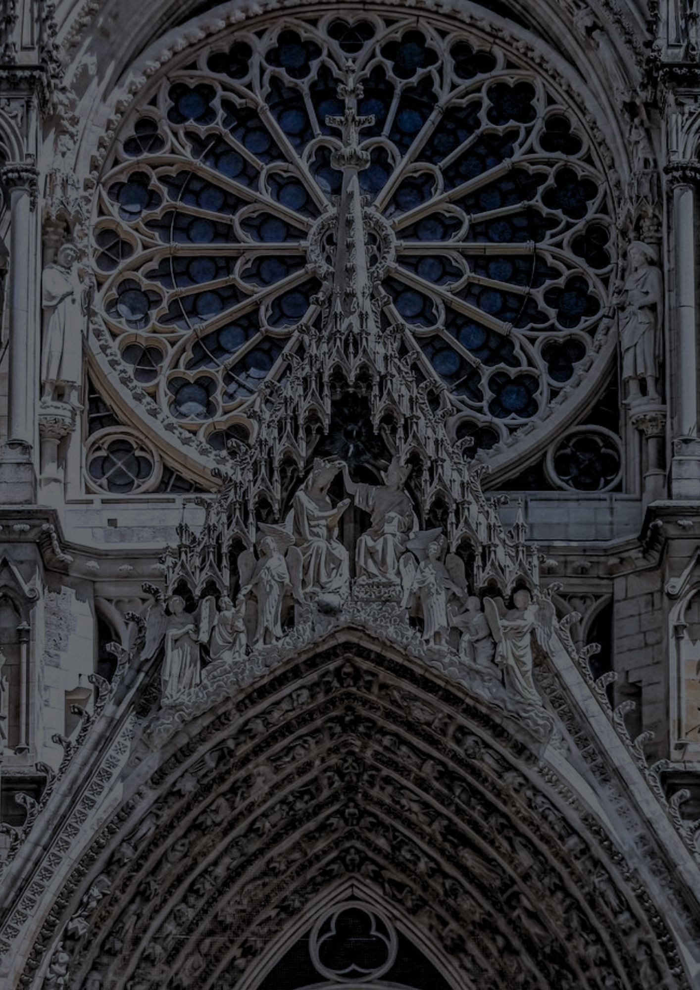 Detail des Eingangsportals einer gotischen Kathedrale mit Skulpturen und Fensterrosetten.
