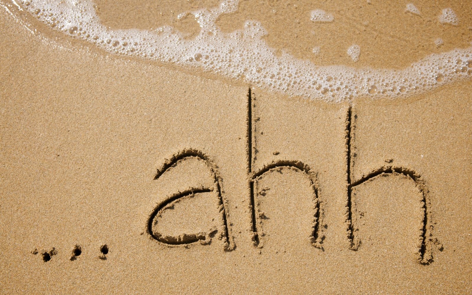 ahh written into the sand on a beach