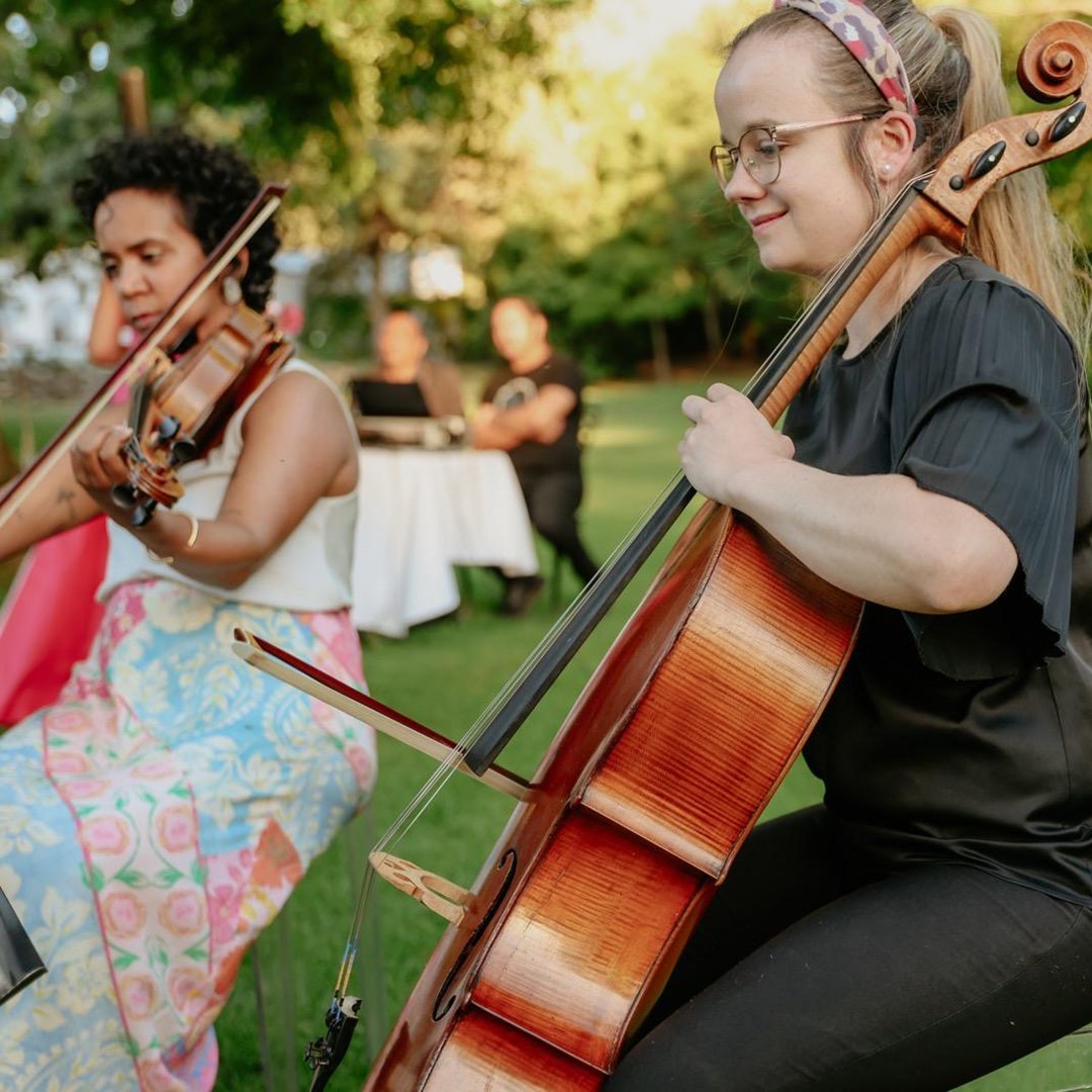 Cape Town Urban Strings playing violin and cello with String Quartet outdoors at a gathering with a DJ in the background.