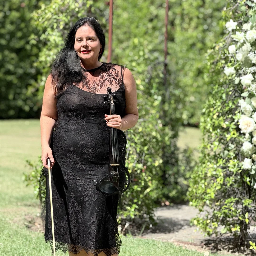 Electric violinist performing at La Paris Estate in Franschhoek surrounded by elegant garden scenery.