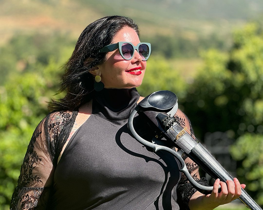 Woman with black hair, wearing large Larah Eksteen, Cape Town violinist, performing at Johannesdal, one of the Cape Winelands' most beautiful wedding and event destinations.