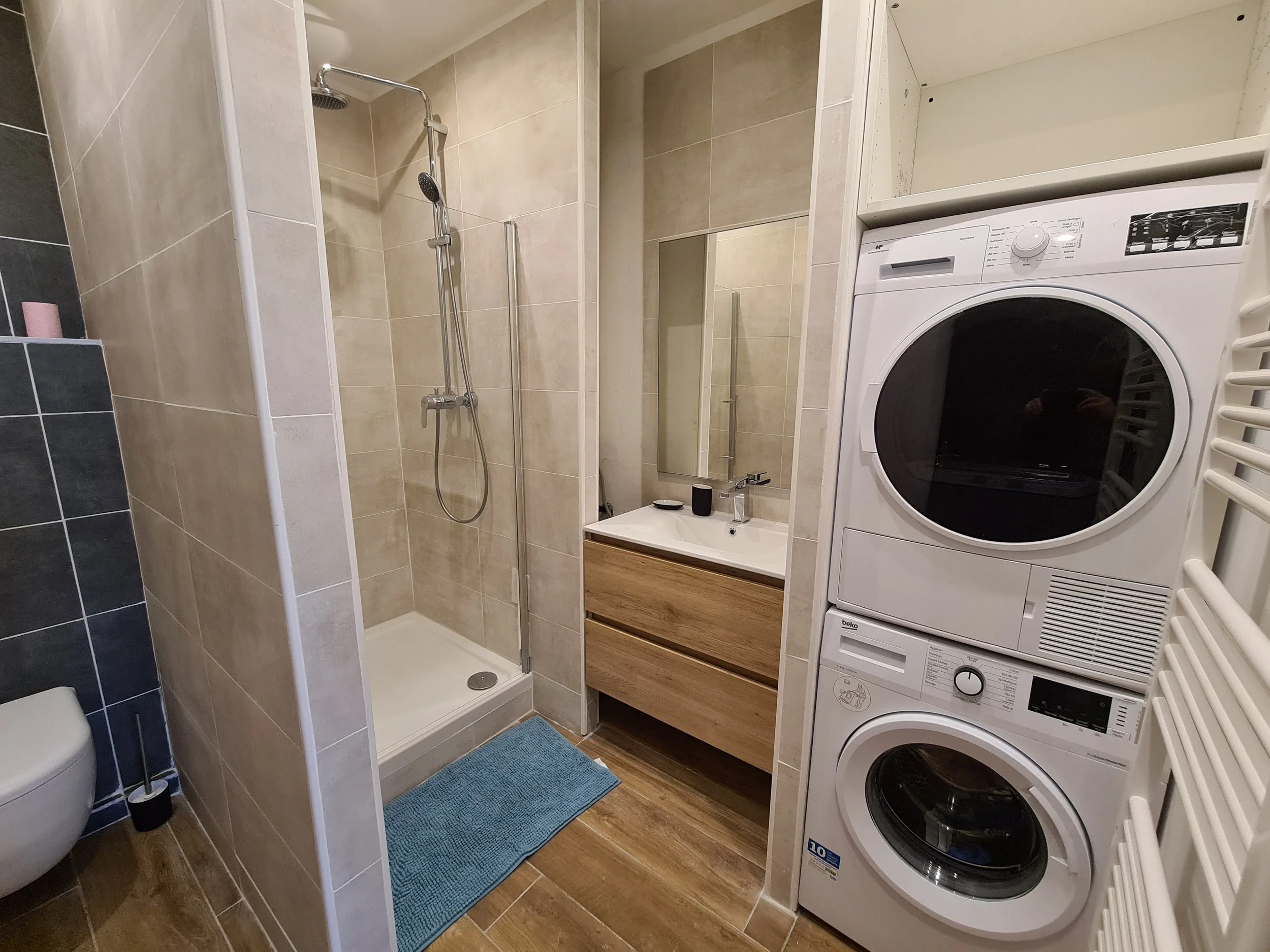 Salle d’eau moderne avec douche, vasque et équipements pratiques à la Villa Donuts.