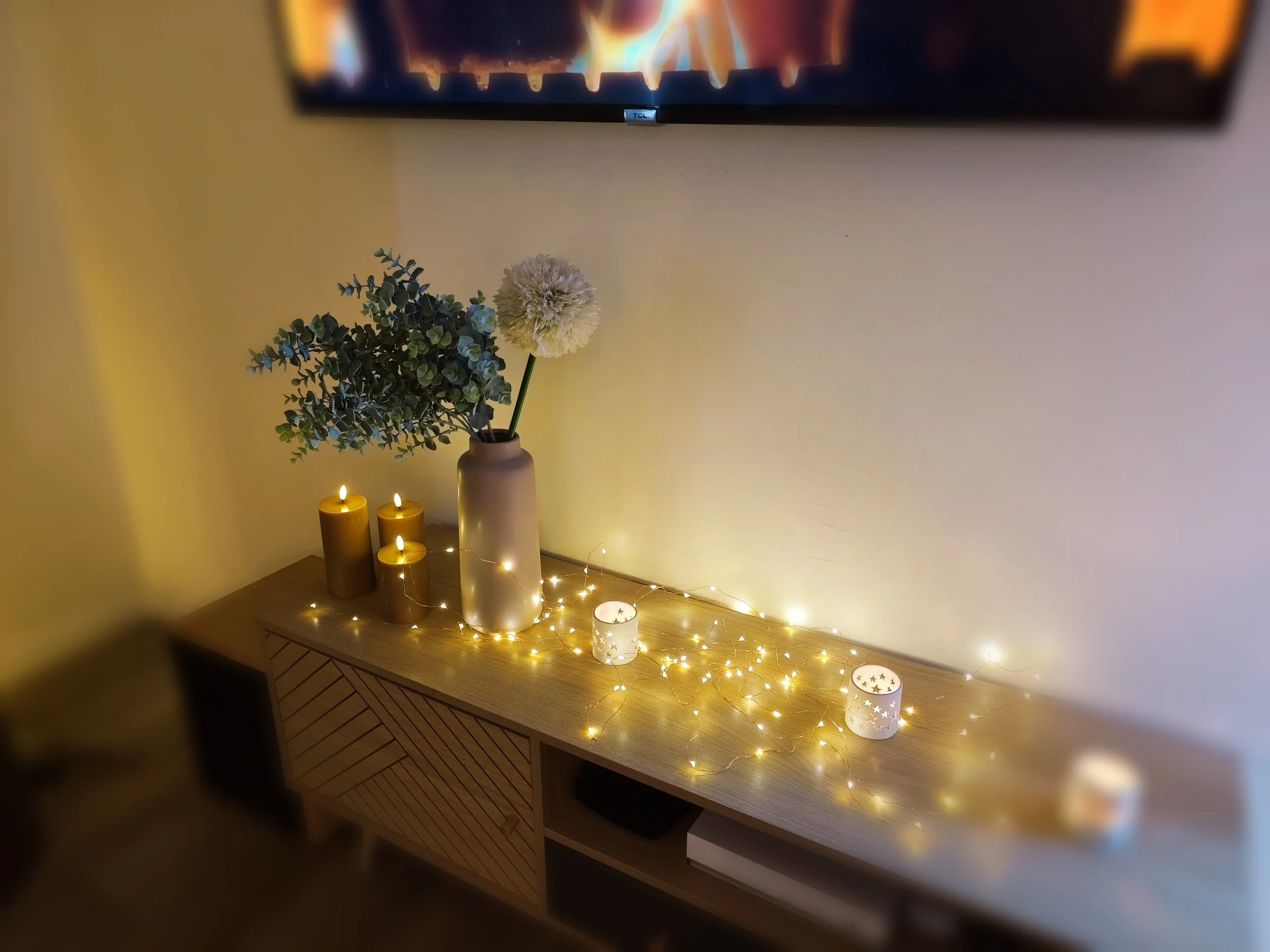 Ambiance chaleureuse avec bougies, guirlande lumineuse et décoration romantique dans la love room Villa Donuts.