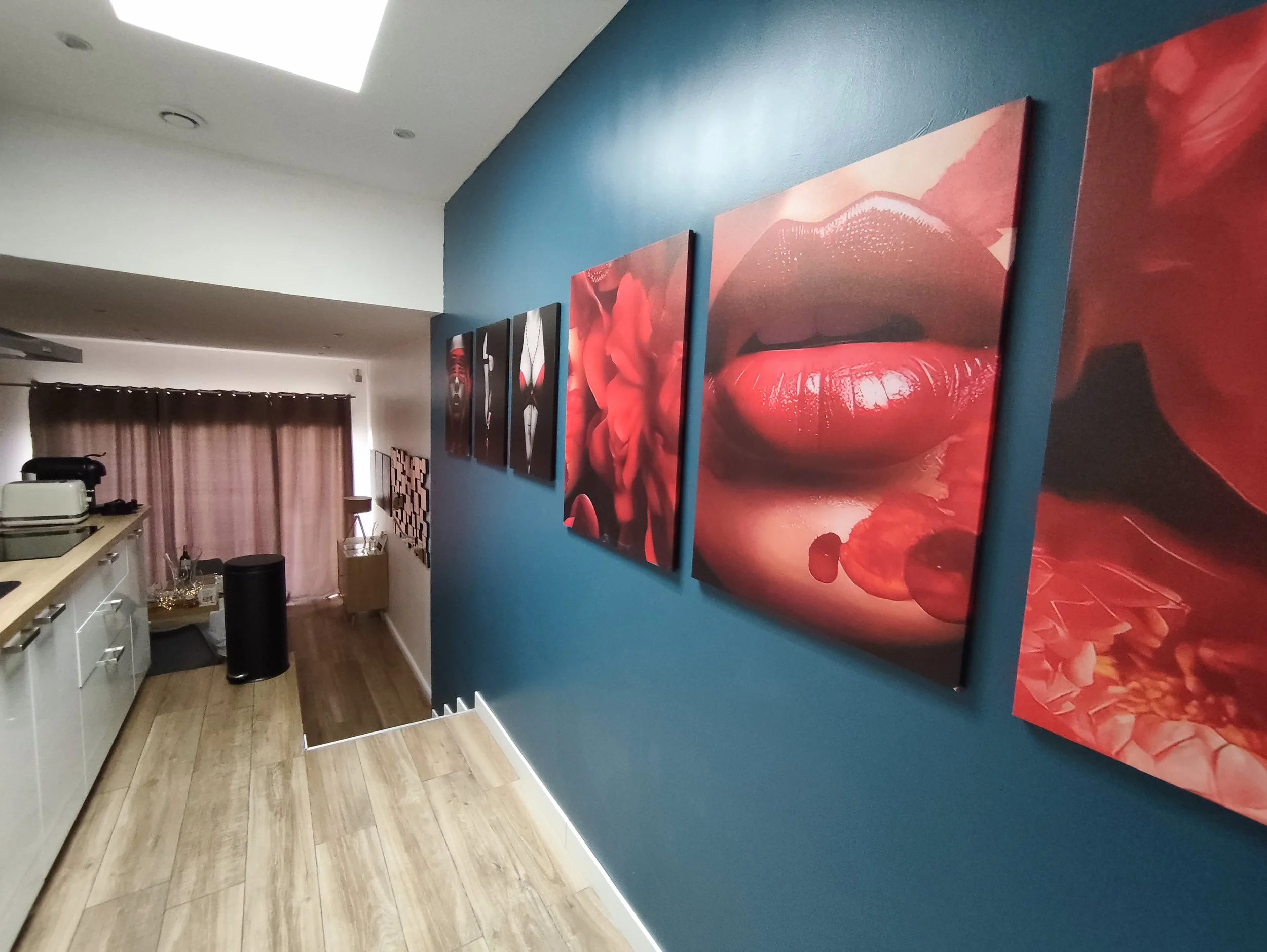 Couloir design de la Villa Donuts avec tableaux rouges et ambiance love room près de Toulouse.
