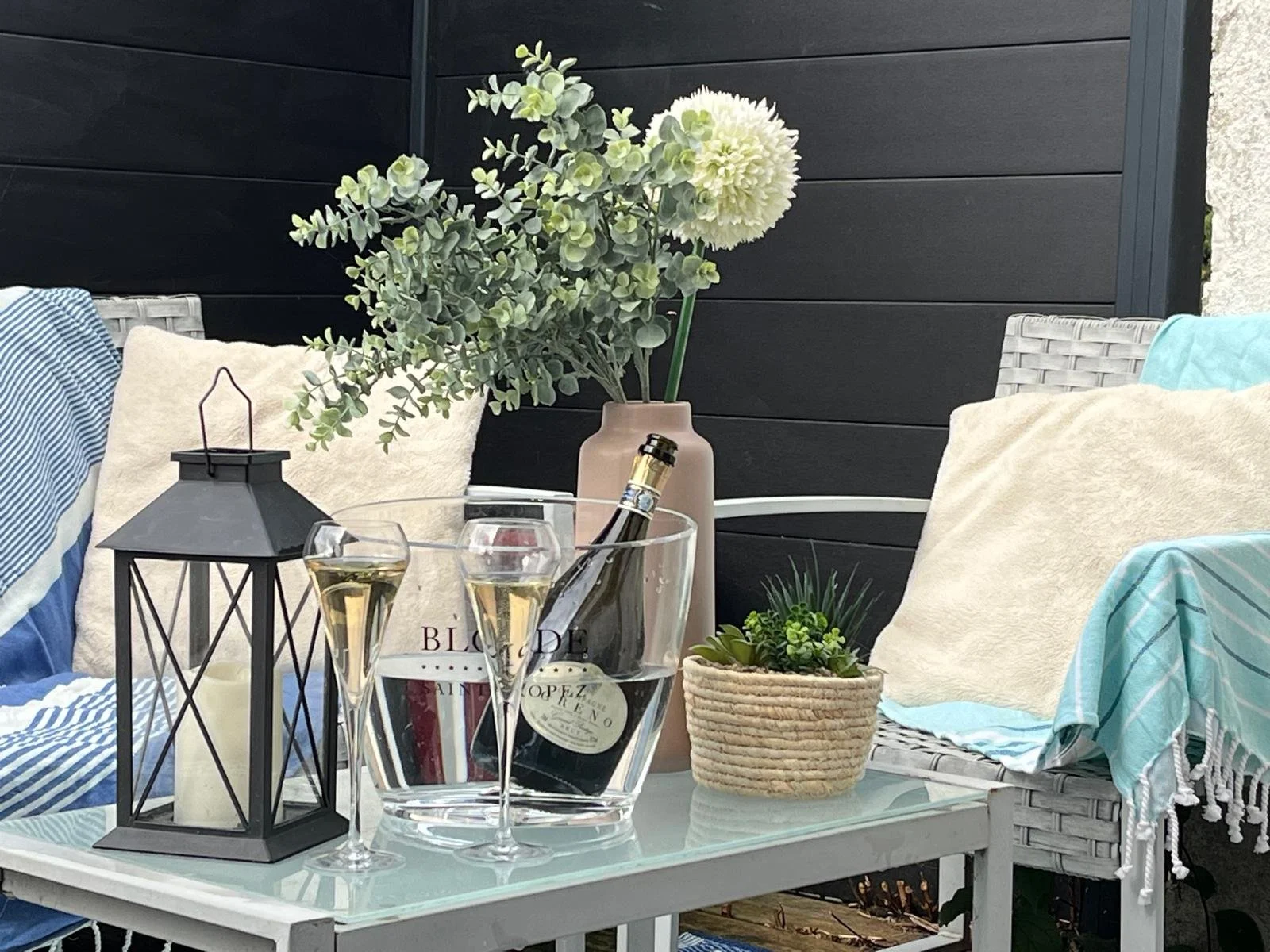 Champagne et flûtes sur la terrasse romantique de la Villa Donuts avec salon extérieur.