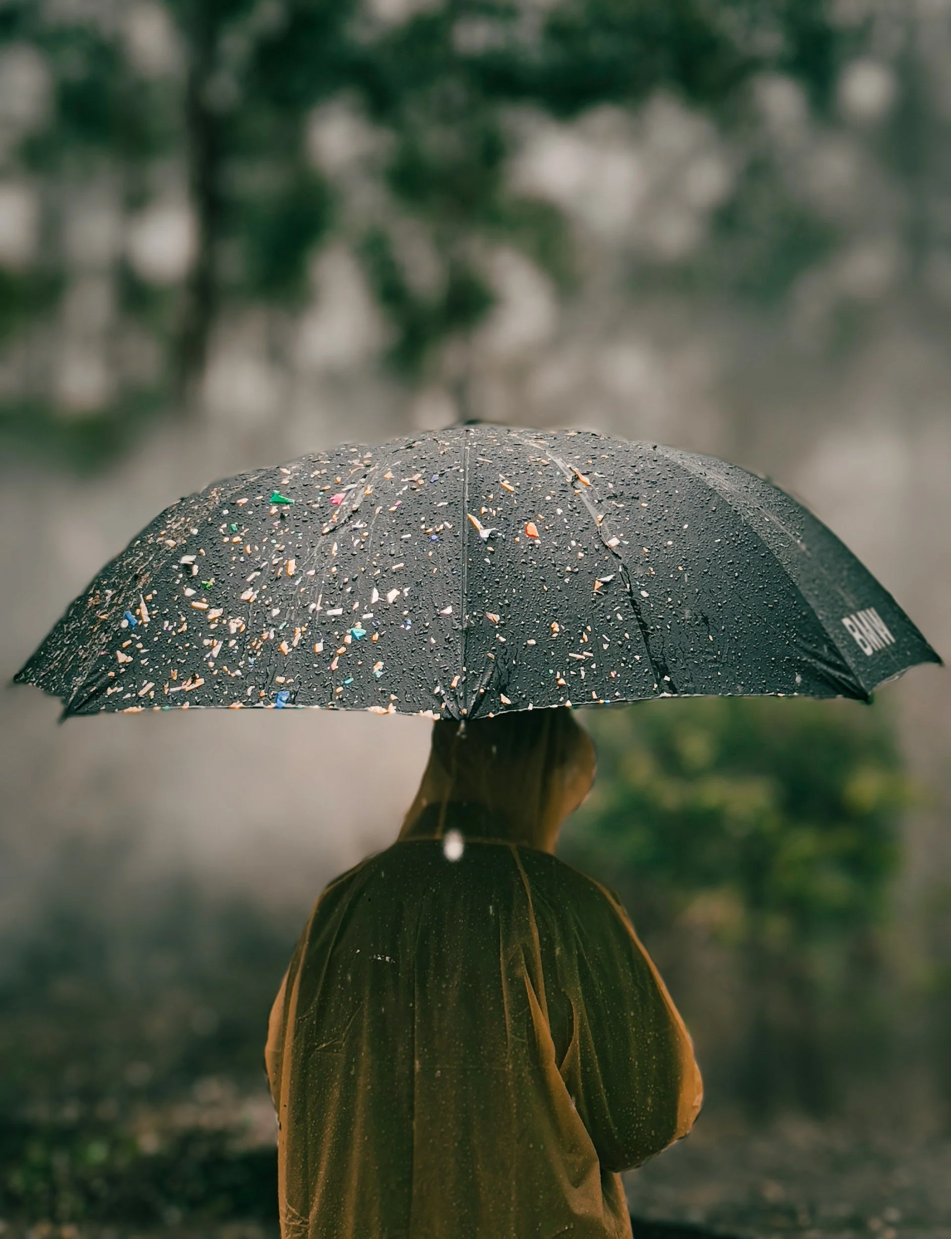 Person sheltering under an umbrella