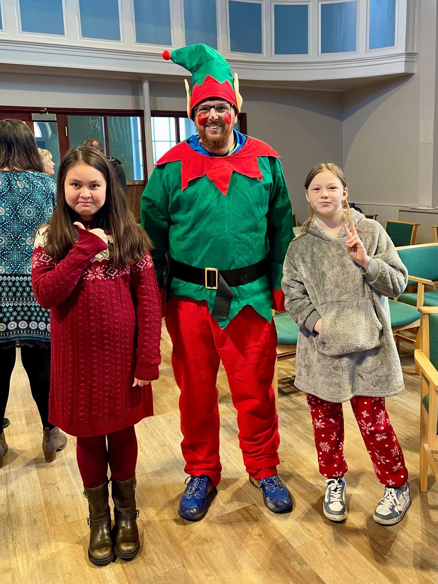 person dressed as elf with two children