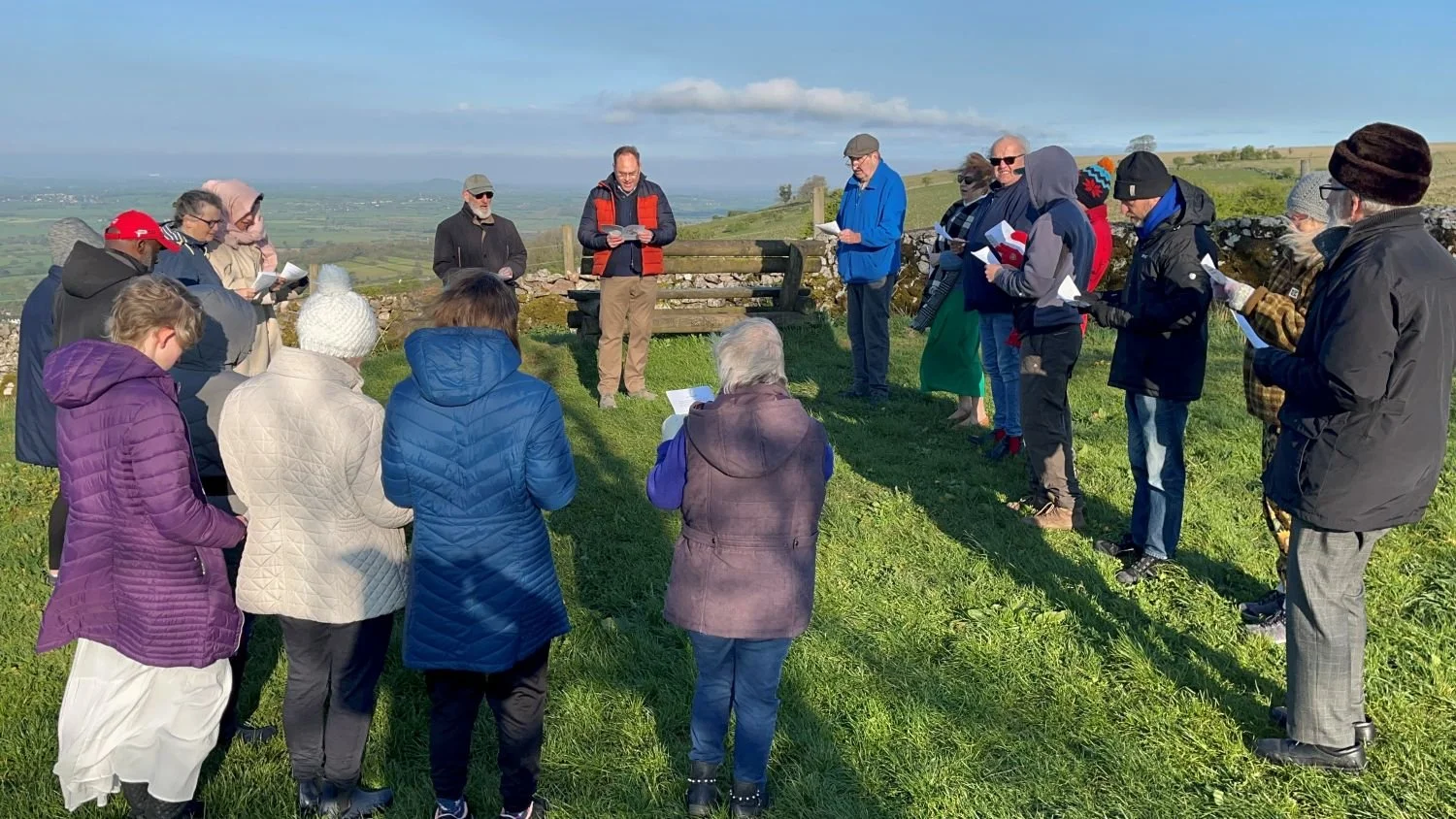 people at an open air service on a hill