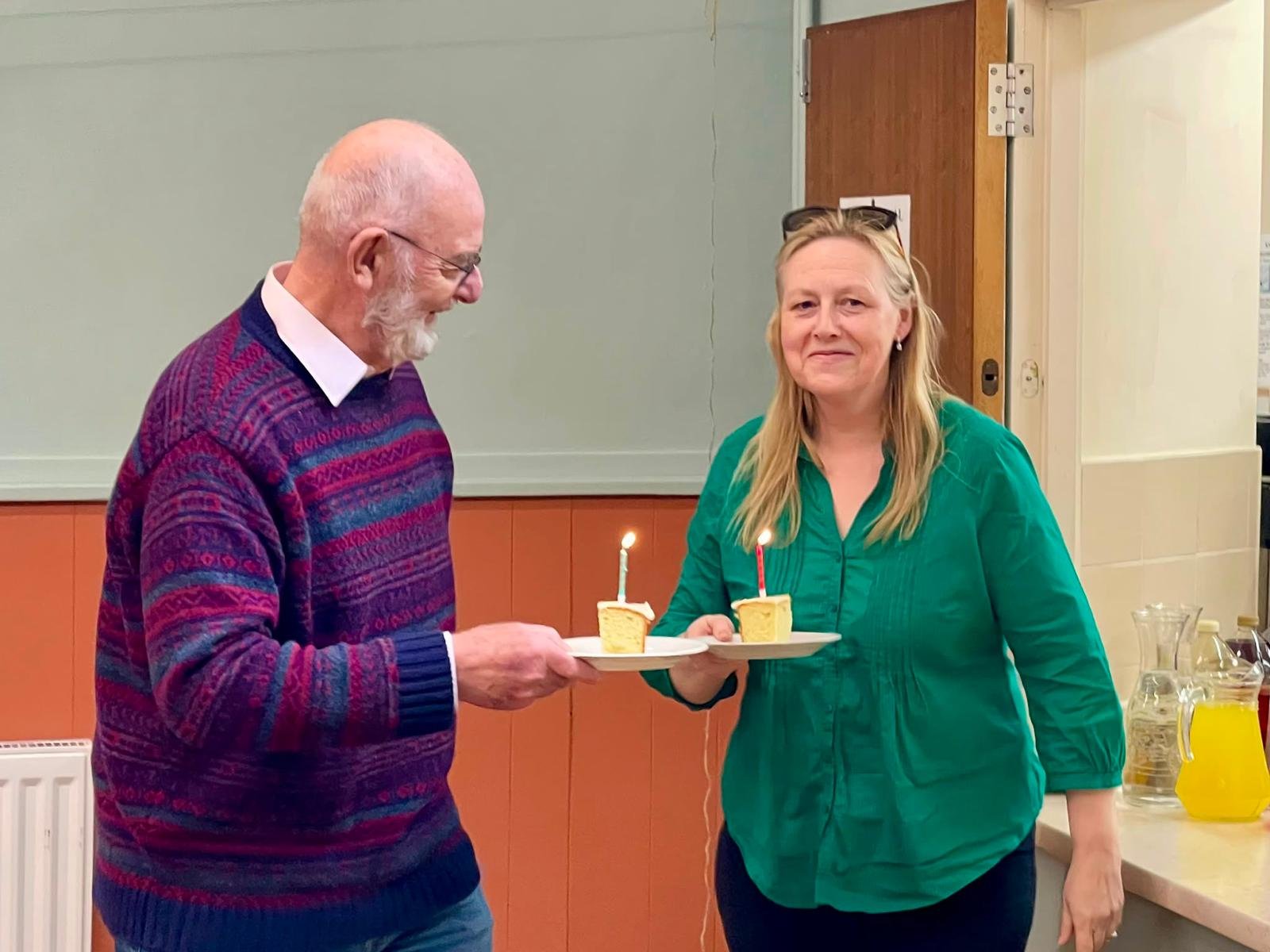 Birthday girl being handed cake with candle