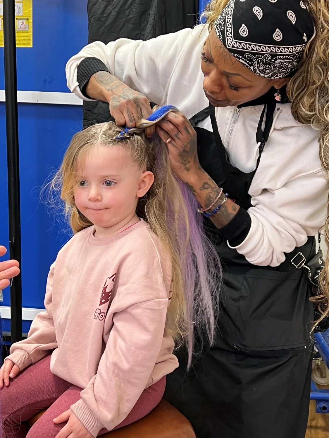 child having hair plaited