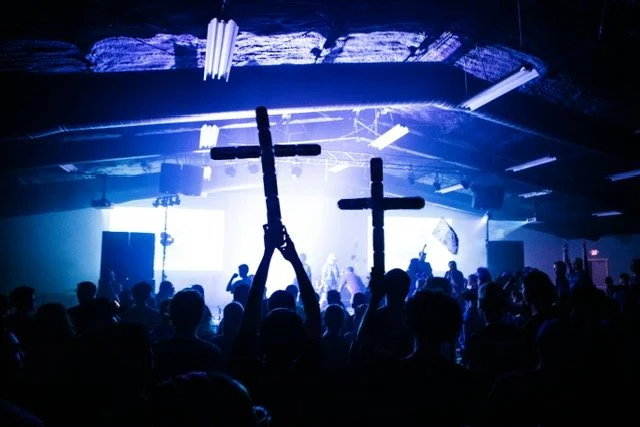 youth concert with people holding crosses up high