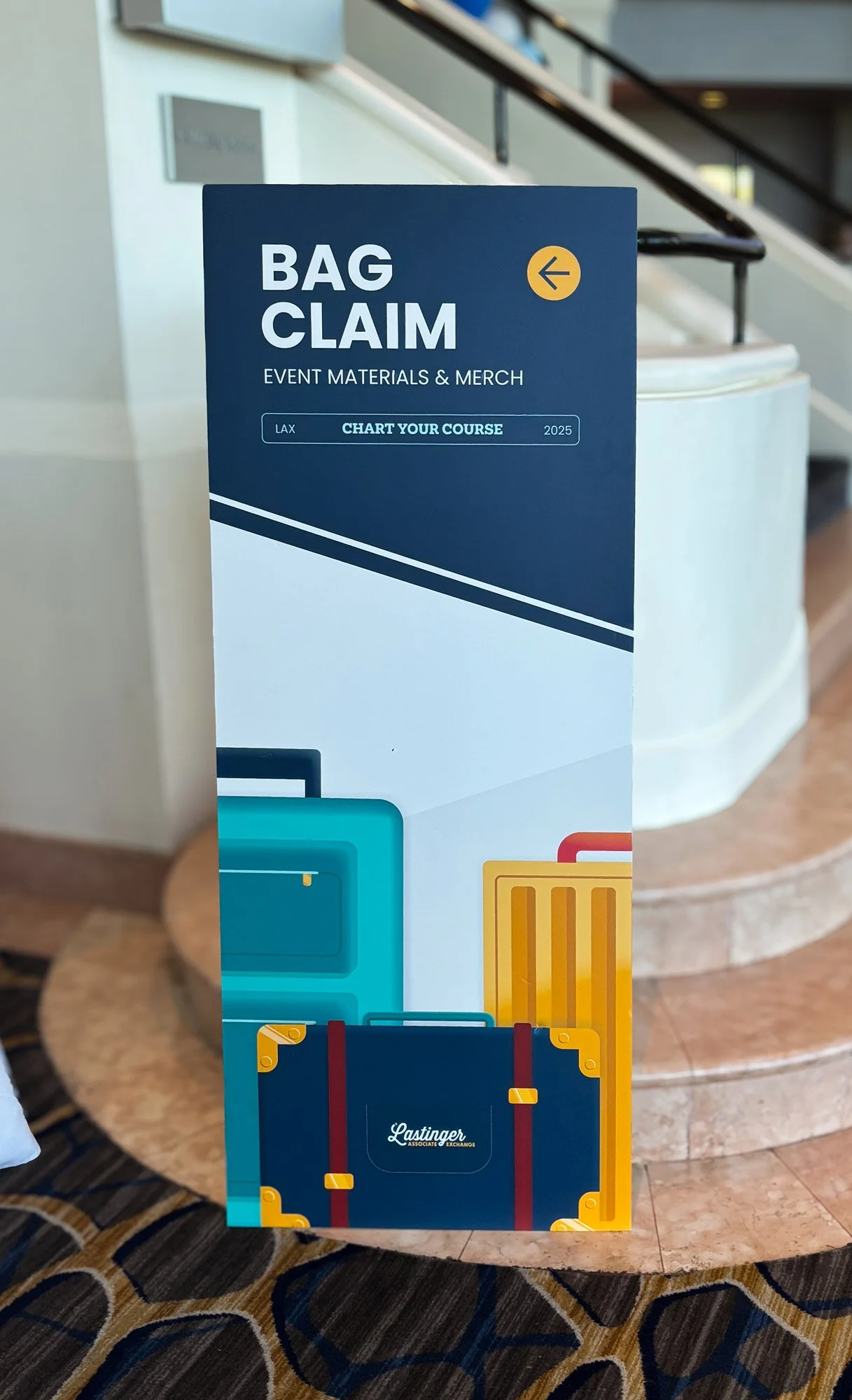 Sign for bag claim area at an event, featuring the phrase 'BAG CLAIM' and an illustration of suitcases, with the text 'EVENT MATERIALS & MERCH' and 'CHART YOUR COURSE 2025'.
