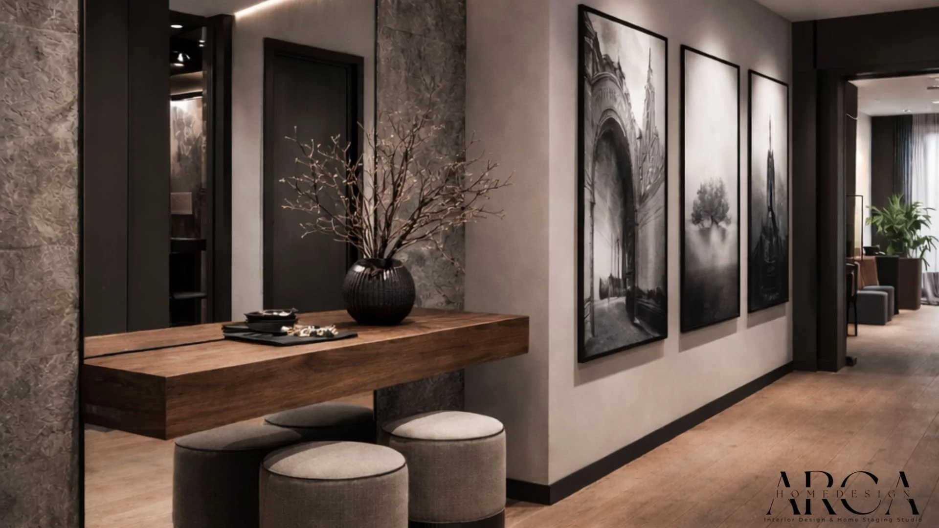 Innenraum mit dunklen Wänden, Holztisch, zwei runde Hocker, große schwarze Vase mit Zweigen, Schwarz-Weiß-Fotografien an der Wand, Wohnzimmer im Hintergrund mit Pflanze und Sitzbereich.