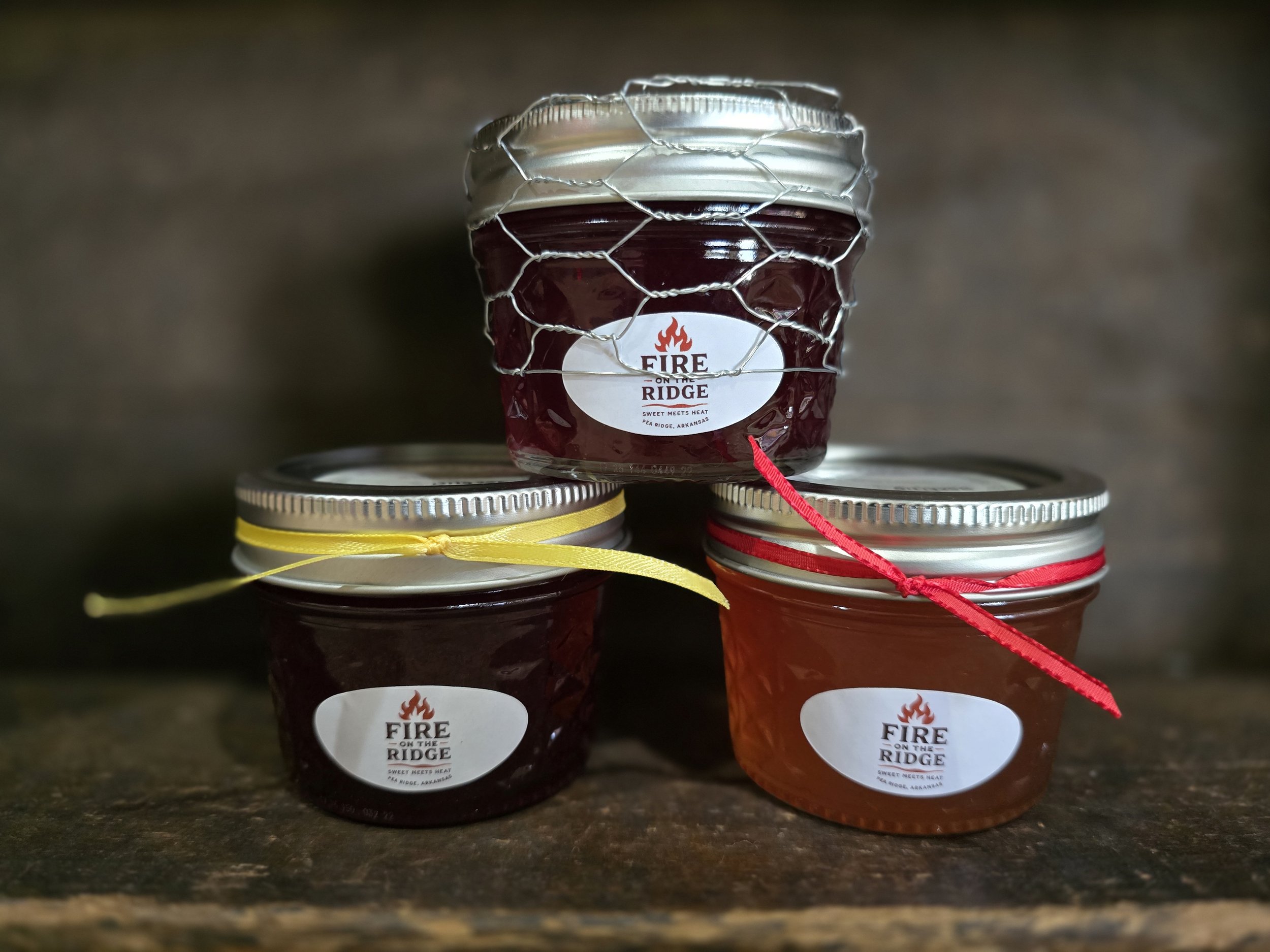 Fire on the Ridge small-batch pepper jelly jars with chicken wire wrap and heat-level ribbon accents.