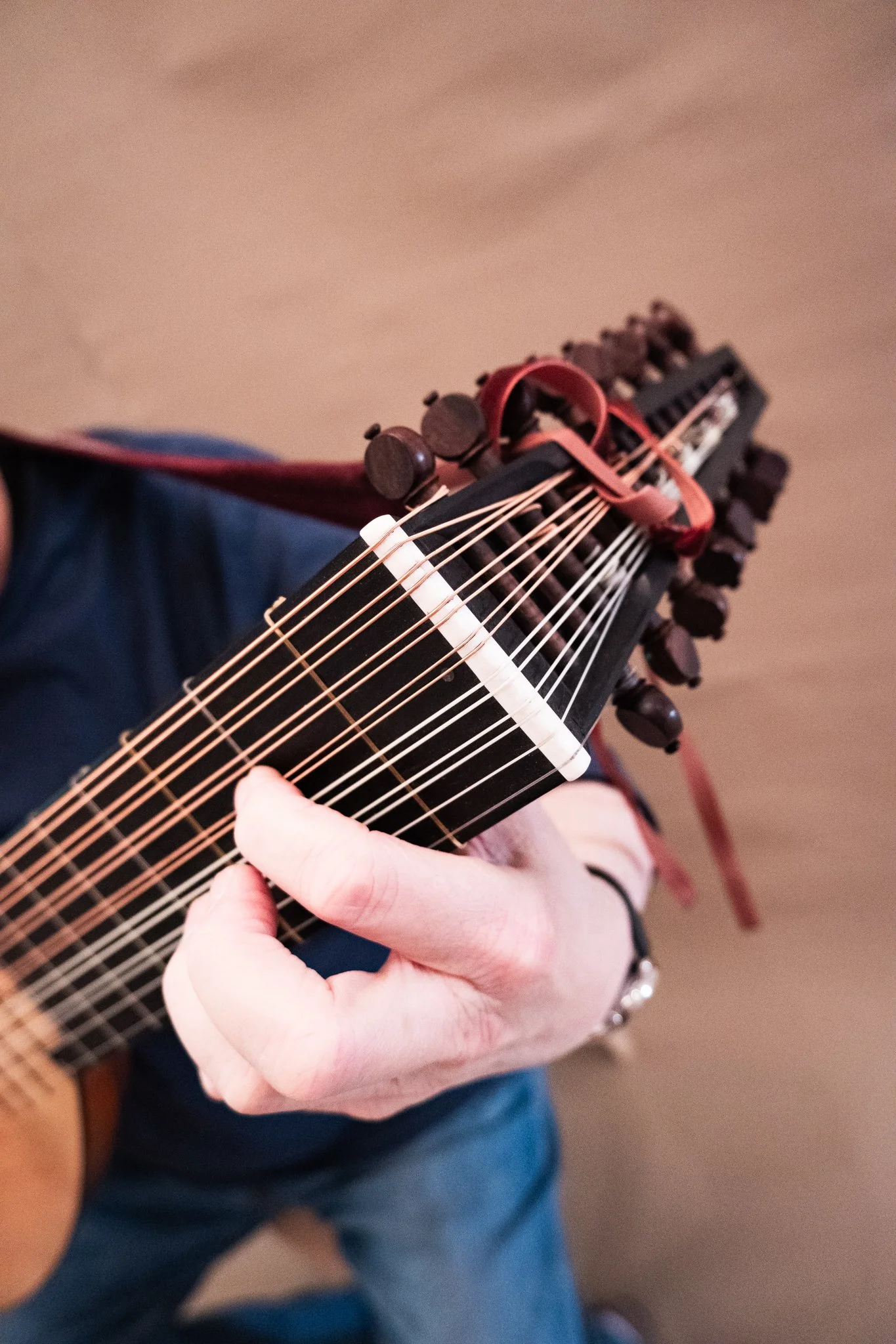 Der Kopf einer Laute mit einer Hand am Griffbrett.