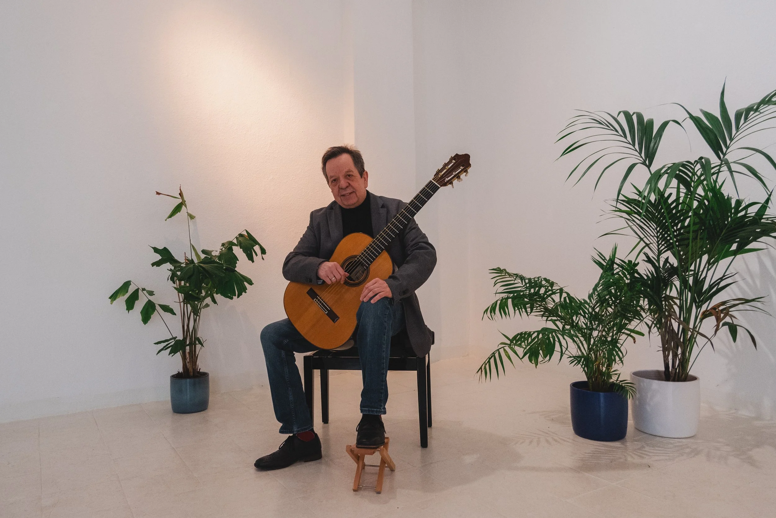 Joachim Schrader mit einer Gitarre und freundlichem Blick in die Kamera.