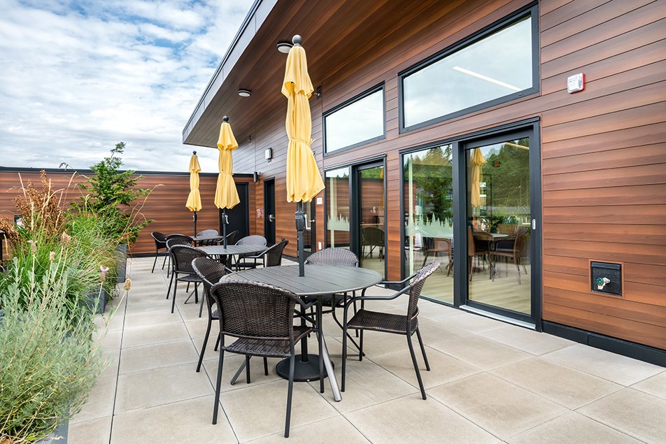 Rooftop terrace with seating, planters, and sliding doors leading to the interior.