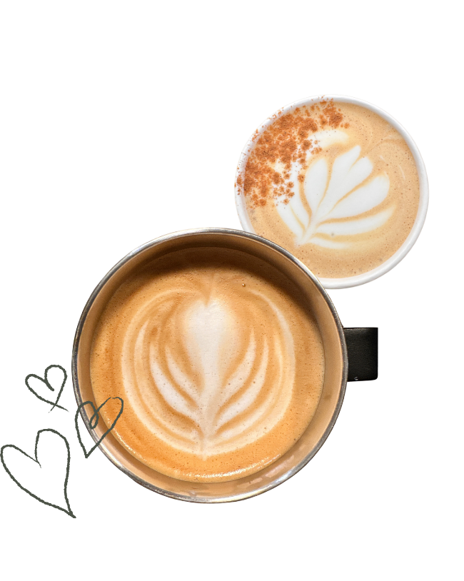Two cups of coffee with latte art, one with a heart-shaped design, and the other with a leaf pattern, on a dark surface.