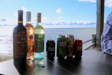 Beverages on a dark table with a view of the ocean in the background