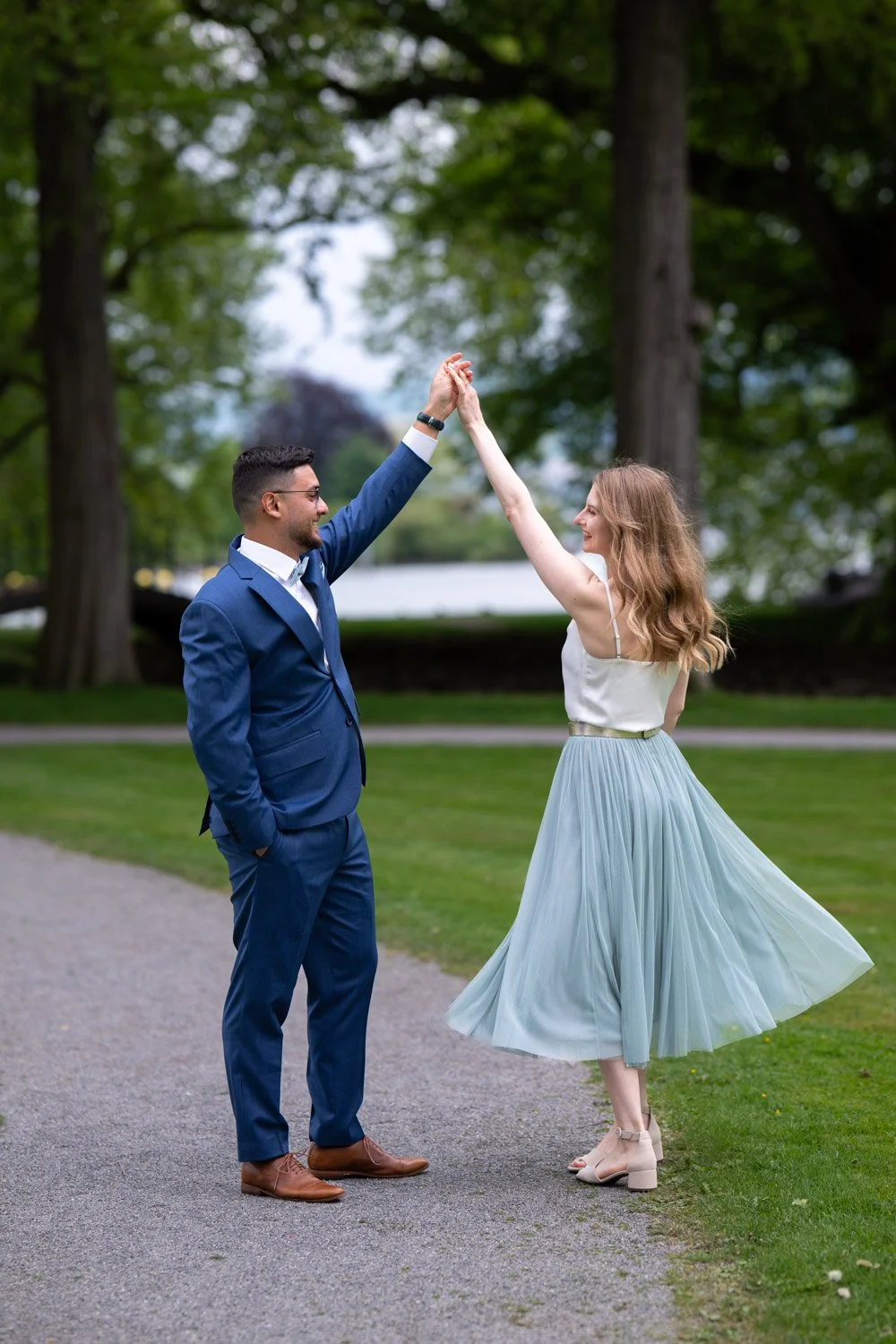 Ein Paar tanzt im Park, umgeben von Bäumen, bei einem sonnigen Tag.