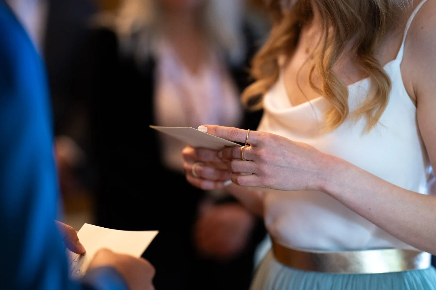 Eine Frau liest einen Brief bei einer offiziellen Zeremonie, vermutlich während einer Hochzeit.