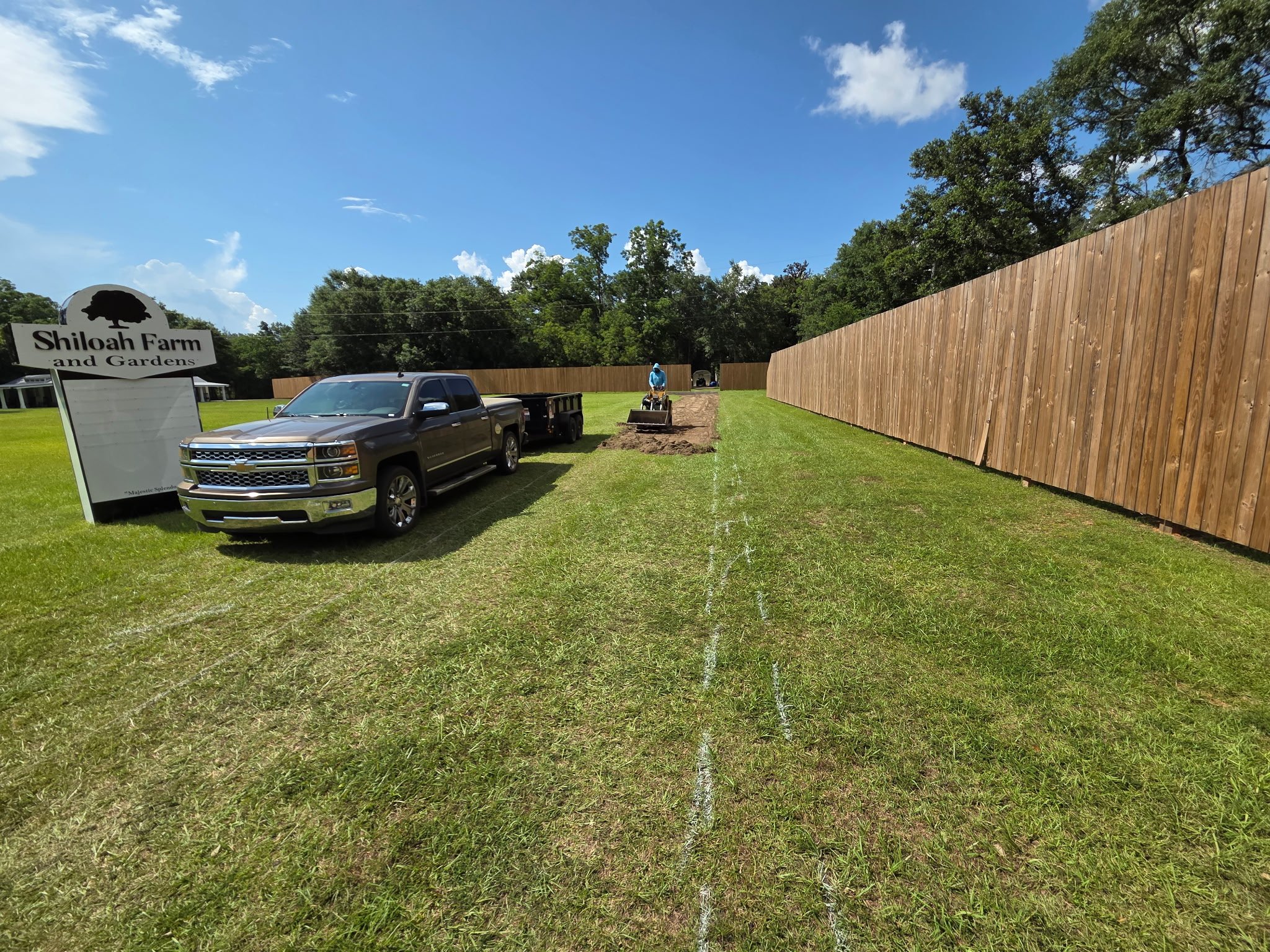 Green grass painted outline machine cutting in new gravel driveway