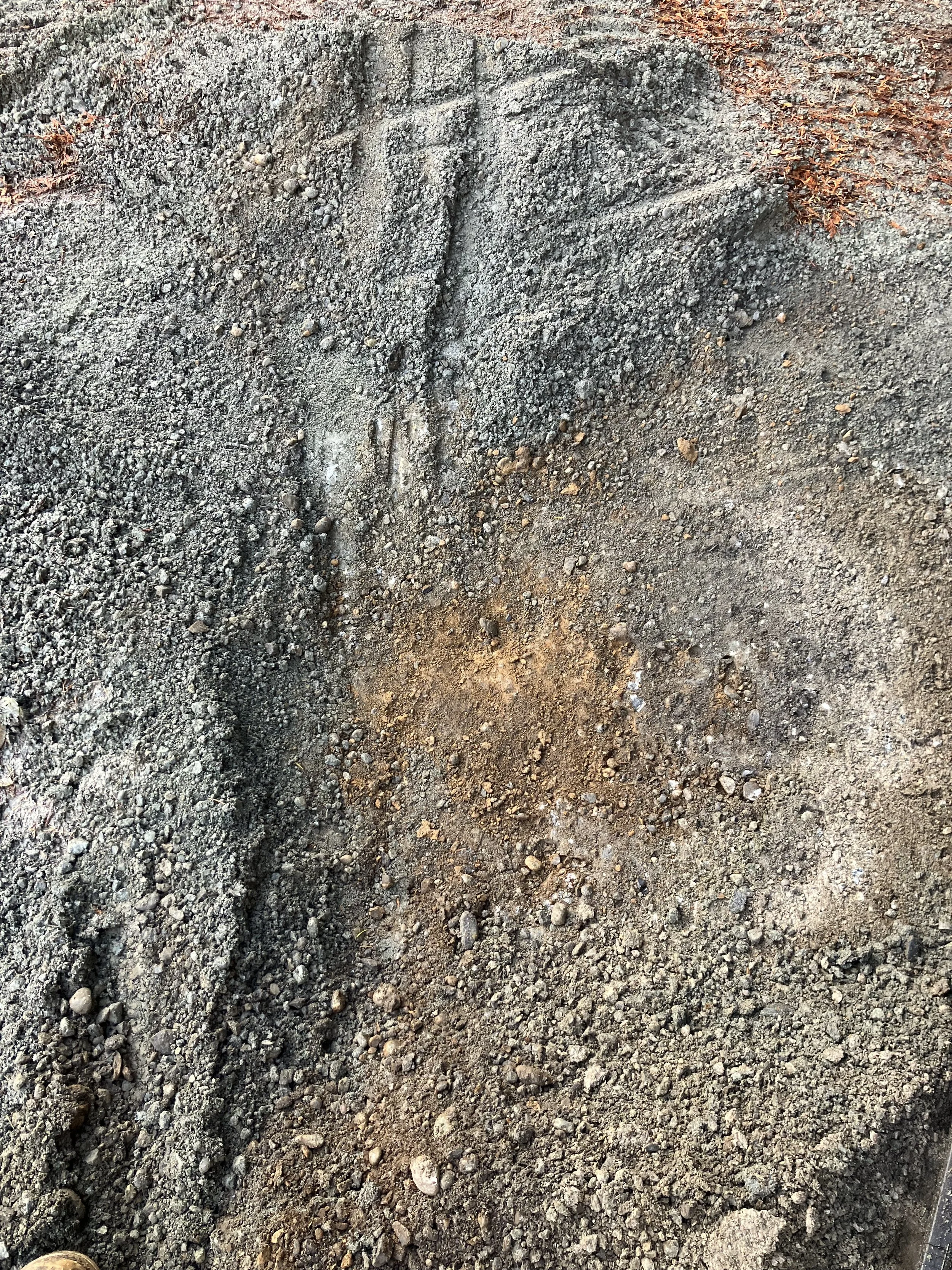 Close-up of disturbed soil with footprints and small rocks.