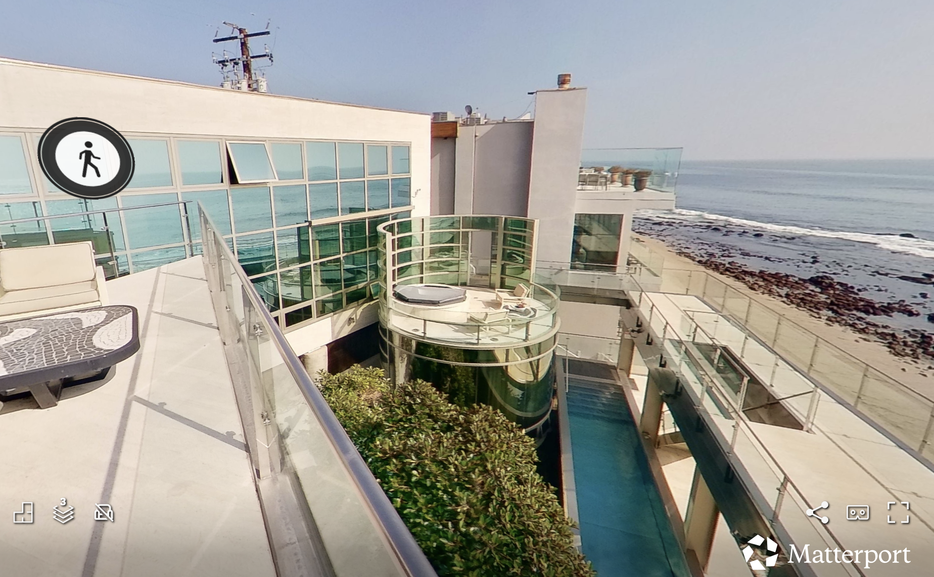 matterport image of a multi-tiered patio with lounge deck, lap pool and beach views
