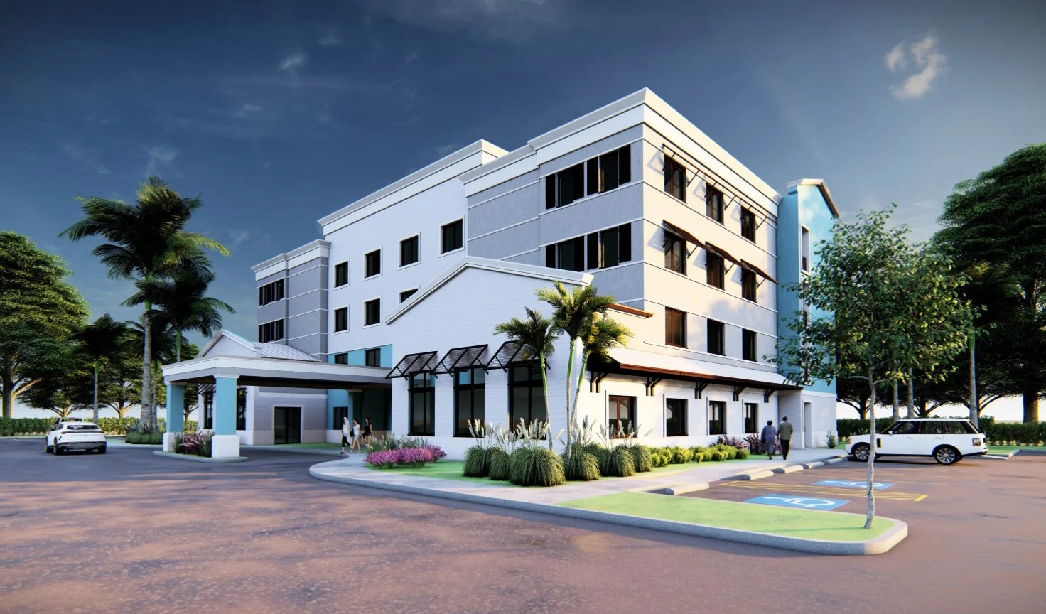 A modern four-story white building with landscaping and parking lot, under a clear sky.