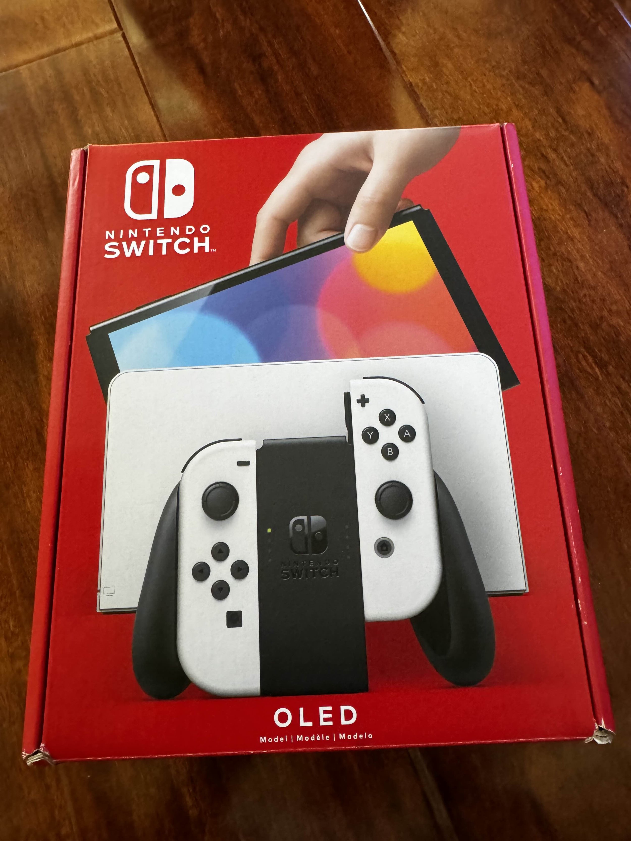 Red box of a Nintendo Switch OLED model with an image of the console and Joy-Con controllers on the front.