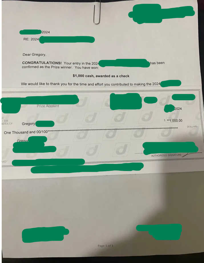 A check announcing a prize win of one thousand dollars, with details redacted and signature at the bottom.