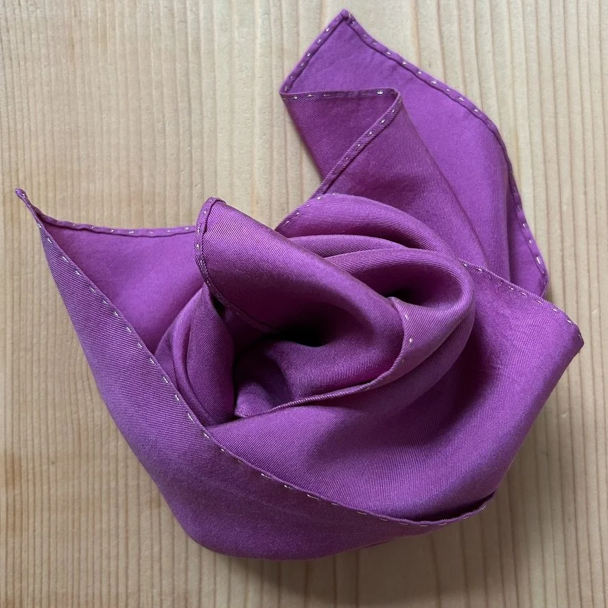 Cochineal silk scarf folded on studio workbench