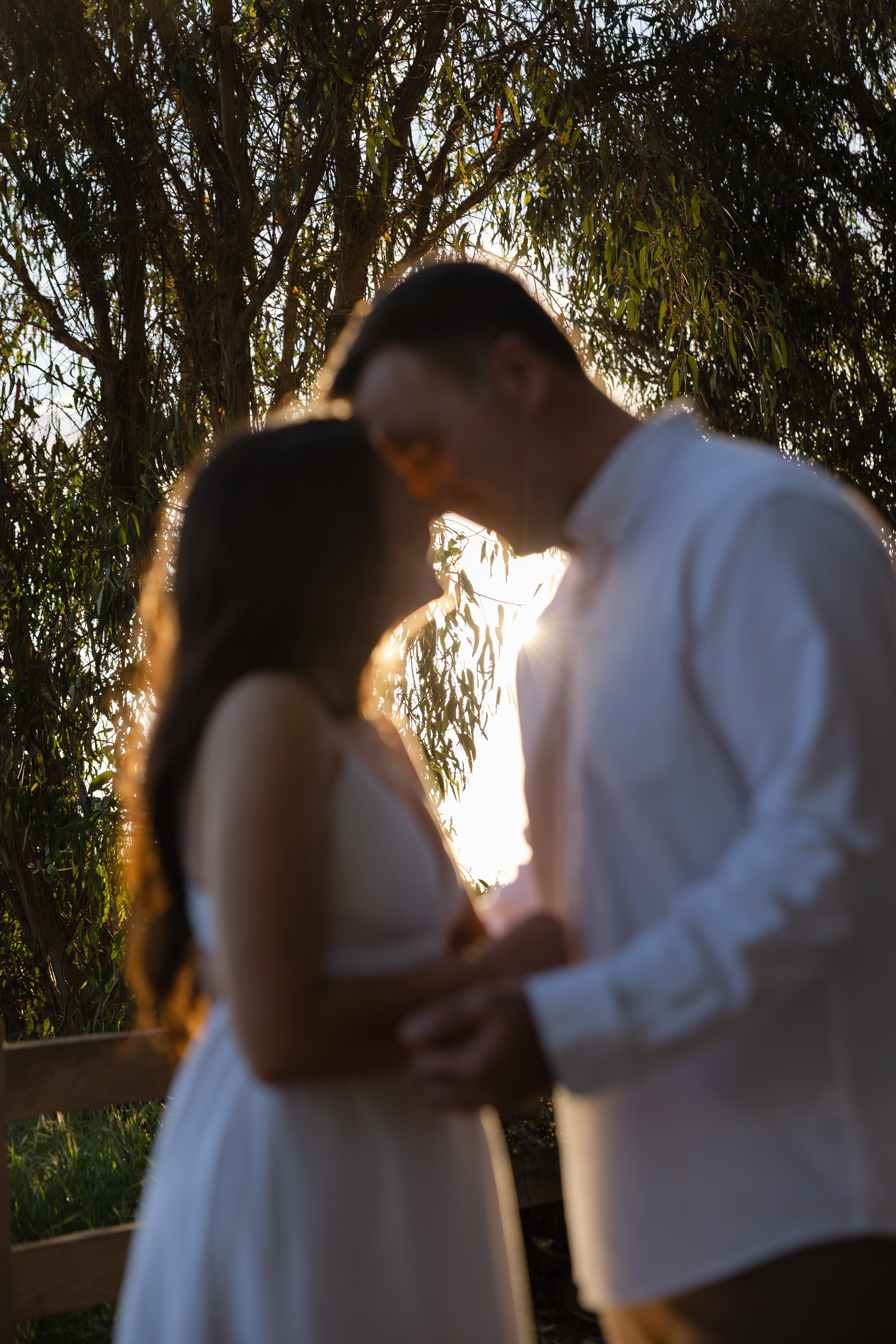 Silhouette of a couple touching foreheads outdoors during sunset