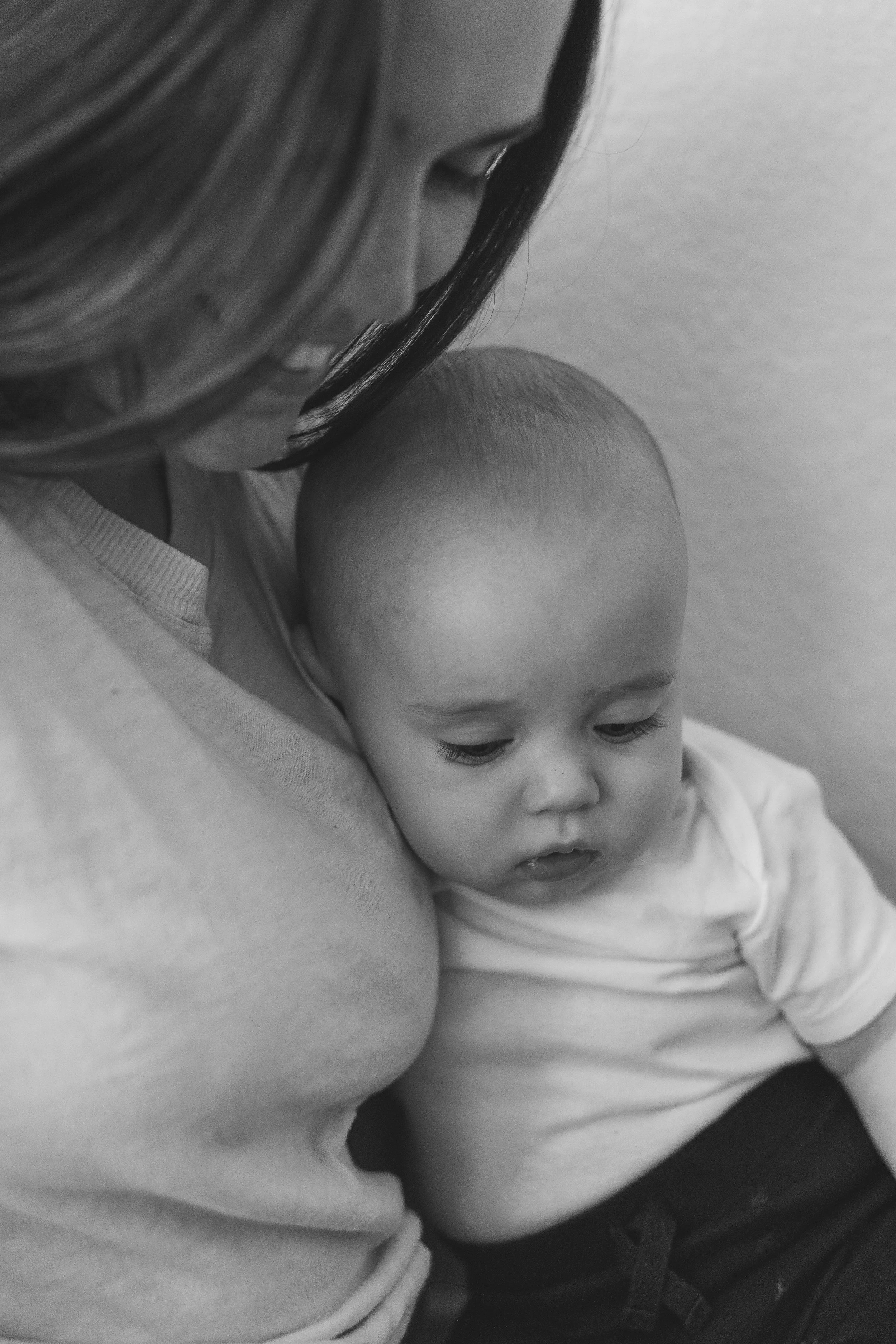 A woman and a young boy resting their heads together, with the woman’s face partially visible, making contact with the boy’s head.