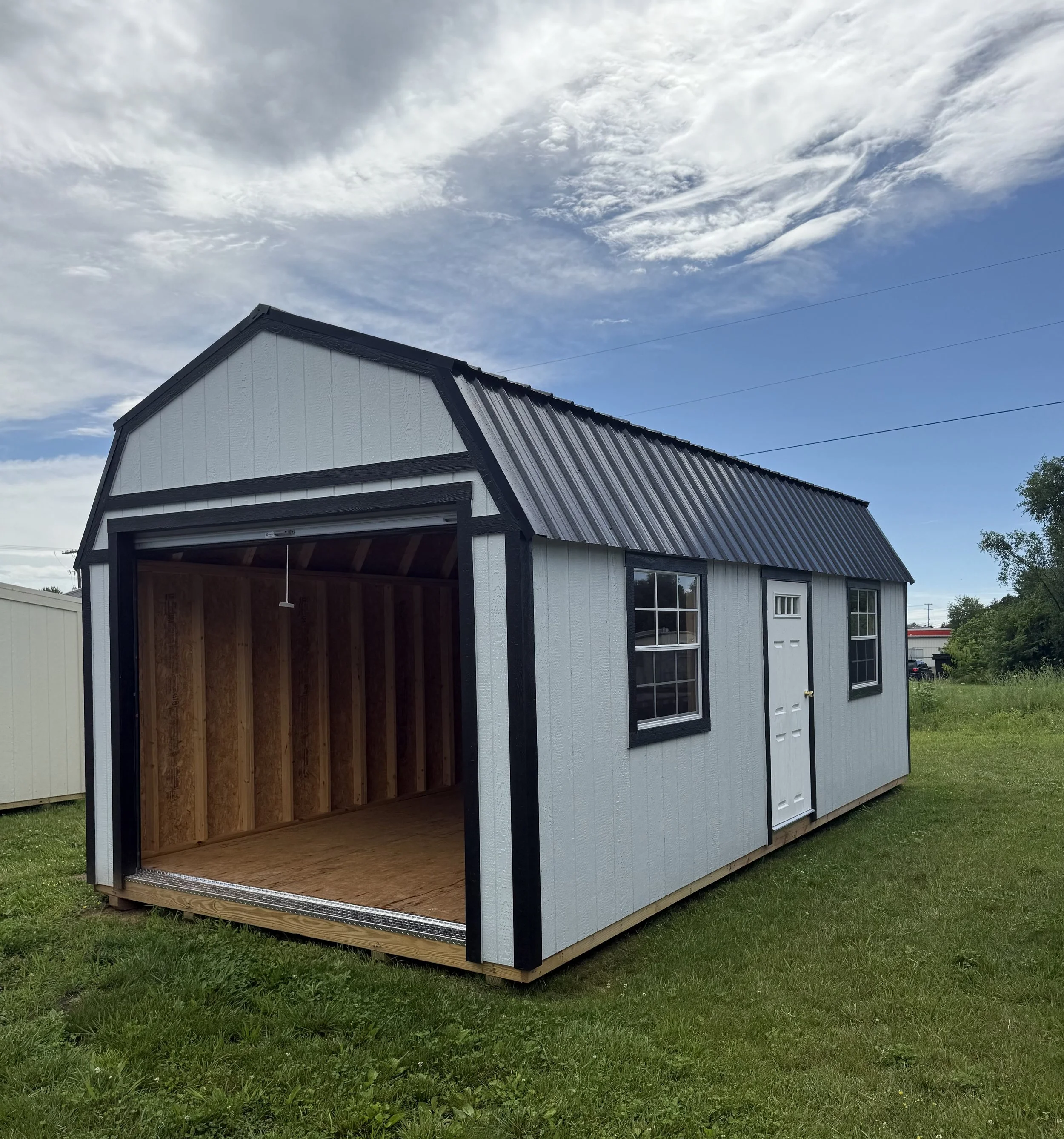 12×24 white and black lofted garage with overhead loft space, large garage door, and contrasting trim.