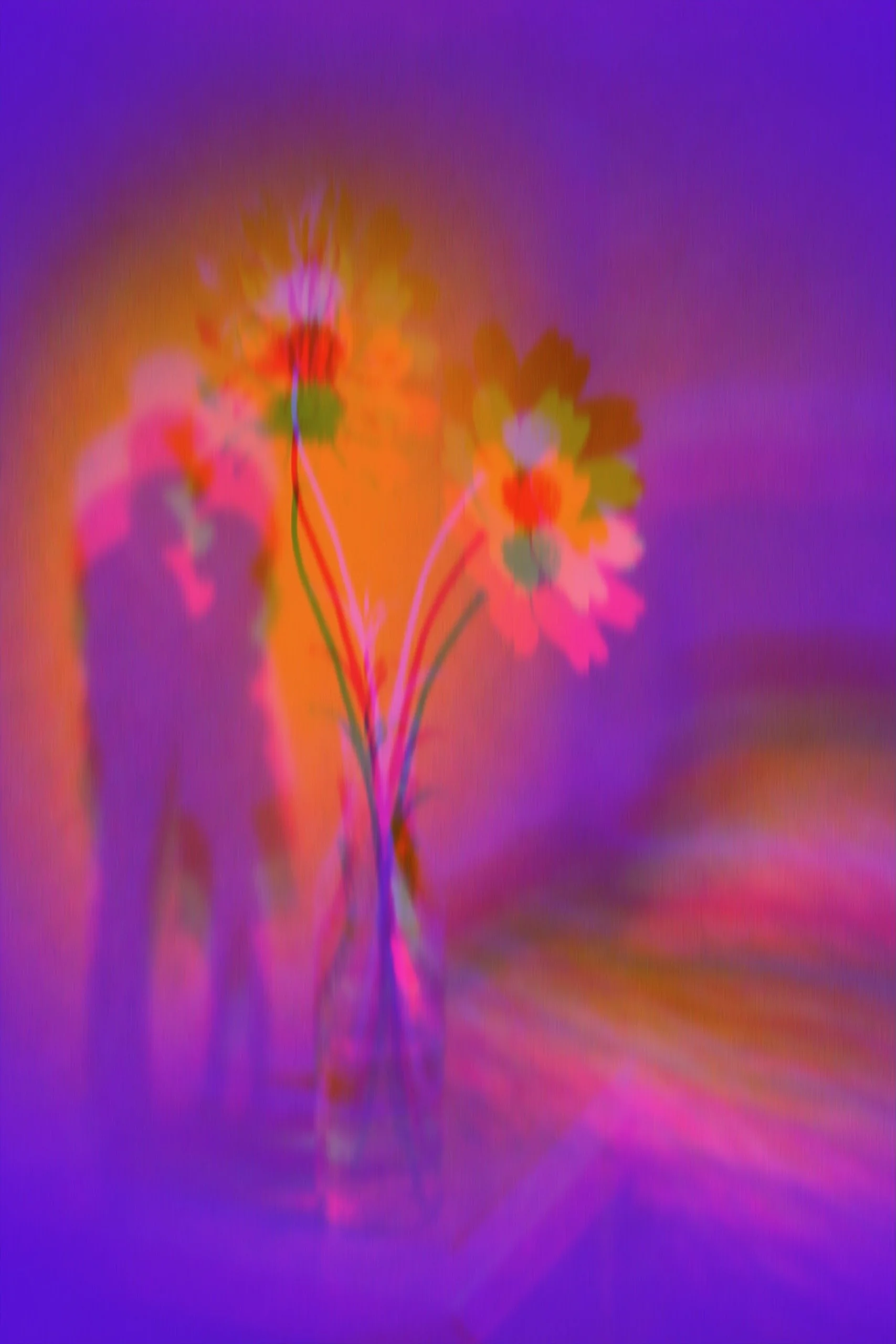 Abstract image of a small bouquet of flowers in a glass vase with colorful and blurred background.