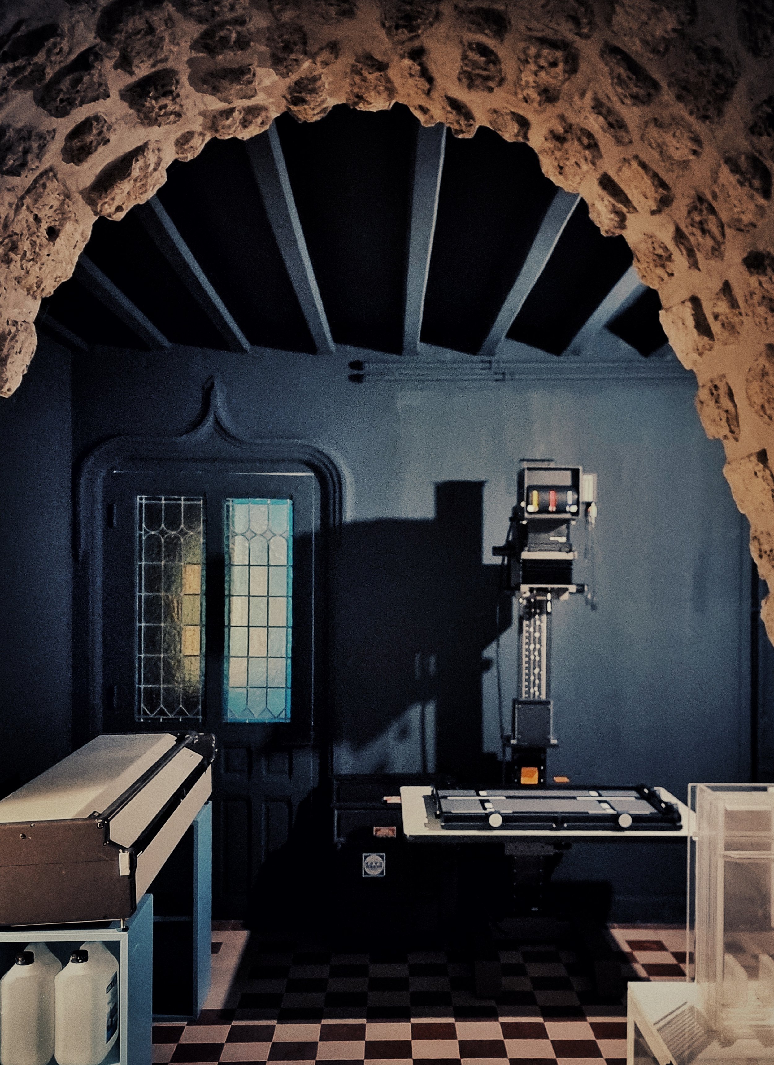 Chambre noire avec mur bleu foncé, lumière faible, mur en pierre au-dessus.