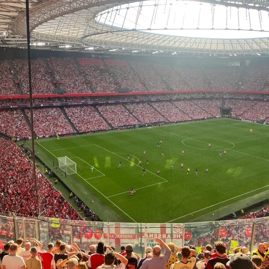 View of a crowded soccer stadium filled with fans, with players on the field during a match.