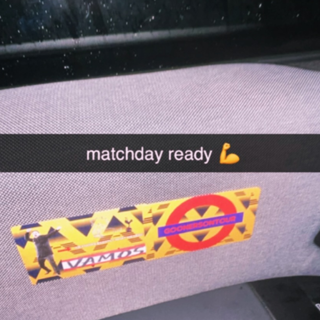 Car dashboard with a message reading 'matchday ready' and a lifted arm emoji, along with a sticker from the London Underground that says 'GOAL!!!'