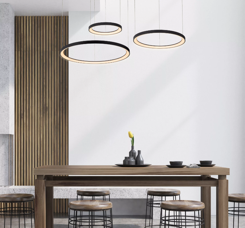 Modern dining room with a wooden table, black wire frame stools, vases with a single yellow flower, and contemporary hanging ring lights.