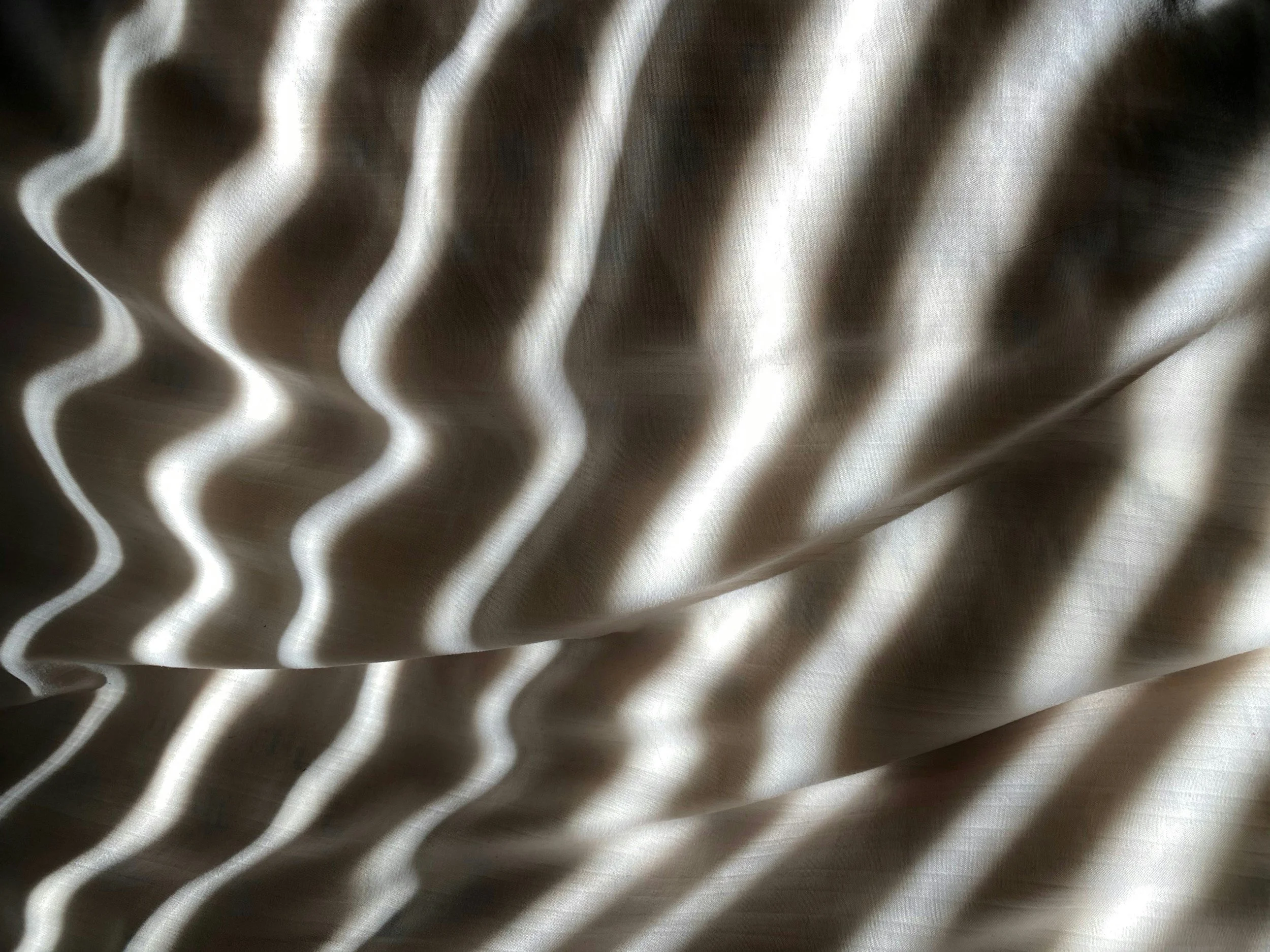 Close-up of patterned fabric with wavy white and brown stripes.