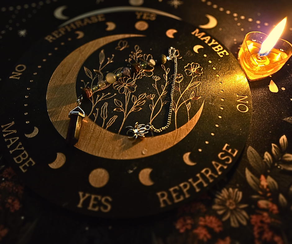 A circular pendulum reading board with phases of the moon, flowers, and words like 'Yes,' 'No,' and 'Rephrase.' A lit heart-shaped candle is placed next to the board, illuminating a beaded pendulum chain.