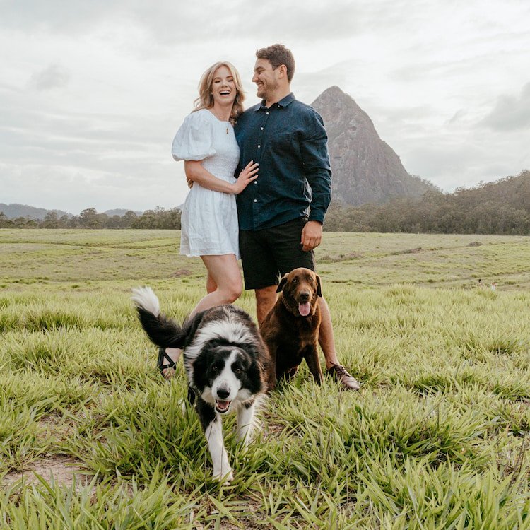 Young couple in front of Glasshouse Mountains with their two dogs at a family photography session