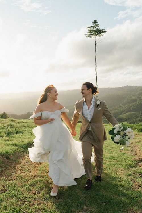 Young married couple running hand in hand in the Sunshine Coast Hinterland at sunset