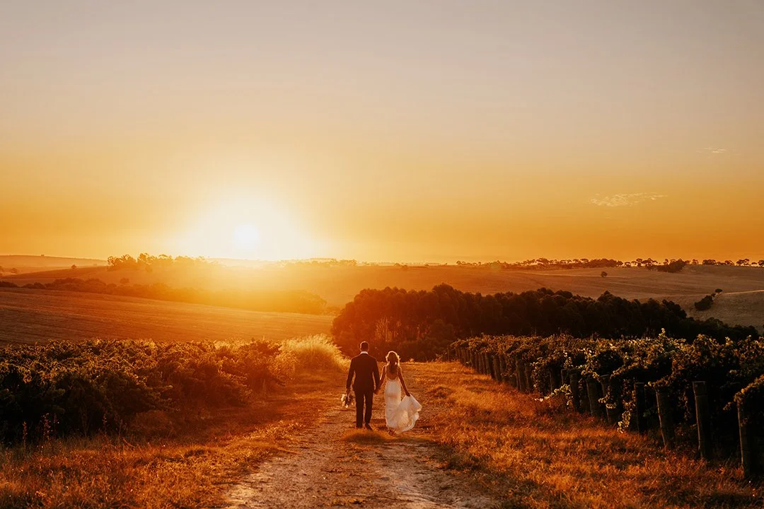 bride and groom at sunset walking away