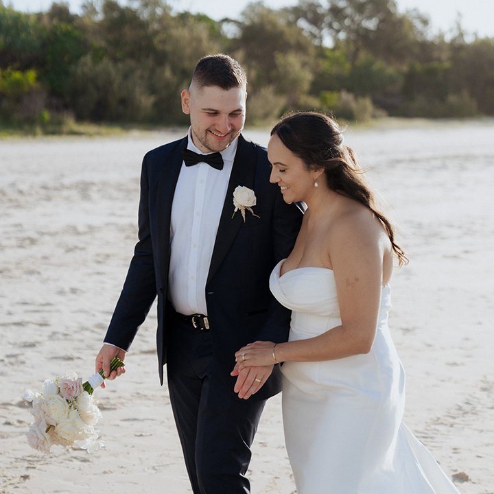 Bride & groom at Noosa wedding walking along the sand on Noosa Main Beach