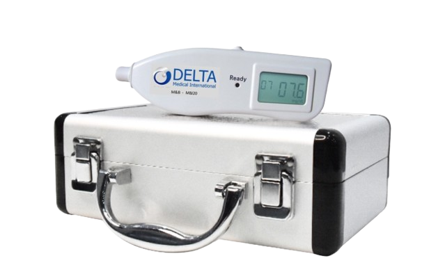 A digital thermometer displaying 07:76 resting on top of a silver briefcase, with a white Delta Medical International device next to it.